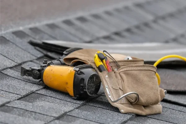 home-verticle1-SRC-Vertical-and-close-up-photo-of-tool-belt-with-nail-gun-and-instruments-lying-on-asphalt-scaled-v3
